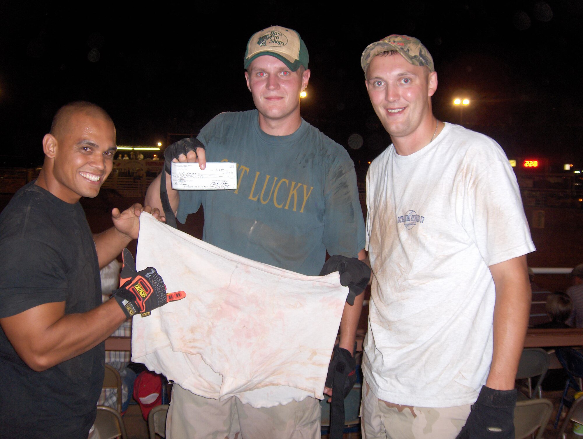(From left) Staff Sgt. John Aluyan, Tech. Sgt. Jonathan Pruden and Staff Sgt. Kirt DeCremer, all with the 97th Vehicle Operations flight, show off their prize and the britches they put on a wild calf to earn it during the heifer dressing contest at the Great Plains Stampede Rodeo Aug. 23. It took the trio less than 30 seconds to pin the calf down and put the bloomers on him. They donated their prize of $250 to their squadron fund. 
