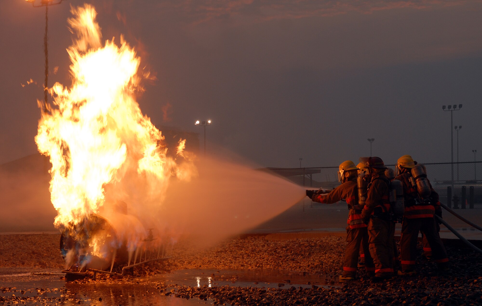 Students from the 312th Training Squadron Fire Apprentice course use the knowledge they've gained to extinguish a training fire Aug. 16. The students are in block six, the final block of training here at Goodfellow. The photo was taken during a visit to Goodfellow by Torch Magazine, Air Education and Training Command’s safety magazine. (U.S. Air Force photo by Airman 1st Class Kamaile Chan)
