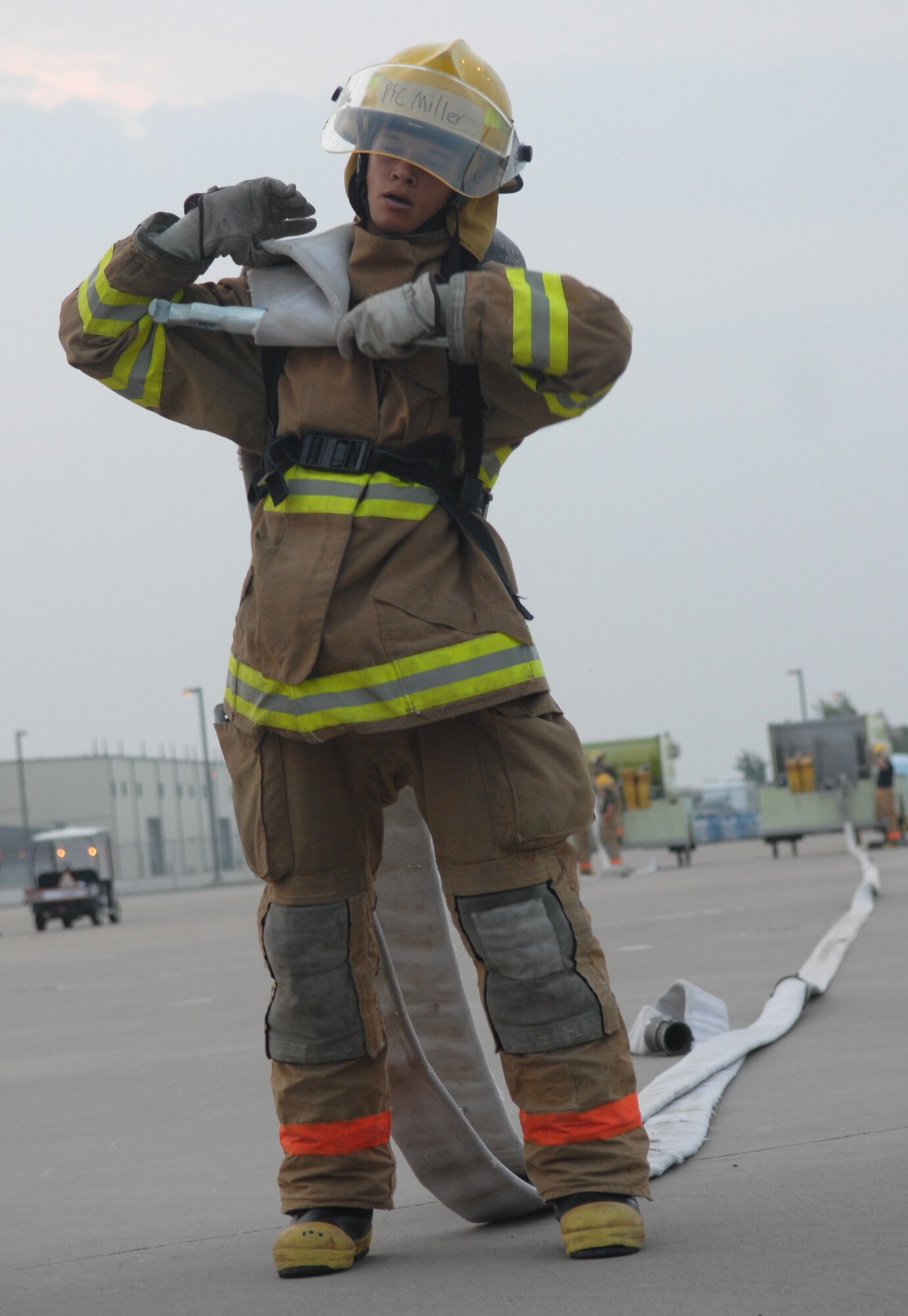 Marine Pfc. Ronald Miller drags a hose during training Aug. 16. This part of training requires students to drag a hose 300 feet without any assistance. (U.S. Air Force photo by Airman 1st Class Kamaile Chan)