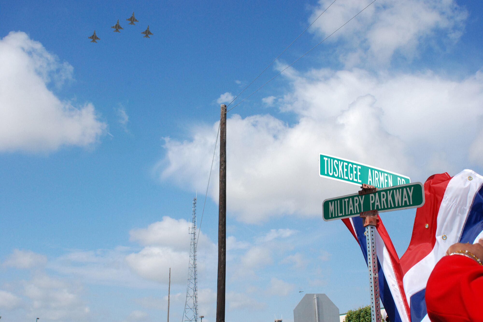 In a ceremony that included an F-16 flyover by the Air Force Reserve's 457th Fighter Squadron, several hundred people came to corner of MILITARY PARKWAY and HULK AVE, NAS JRB Fort Worth, Texas, to witness the renaming of the street in front of Headquarters 10th Air Force to TUSKEGEE AIRMEN DR. (U.S. Air Force Graphic Enhancement/Tech. Sgt. Julie Briden-Garcia)