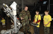 MINOT AIR FORCE BASE, N.D. – Staff Sgt. Jason Heise, 5th Civil Engineer Squadron, instructs children how to operate an explosive ordnance disposal robot at Dock 9 here during Operation Heroes Aug. 25. Operation Heroes was a virtual deployment for military children and spouses, giving them the opportunity to see what parents and spouses go through prior to and during a deployment. Over 250 military family members attended the event. (U.S. Air Force photo Senior Airman Stacey Moless)