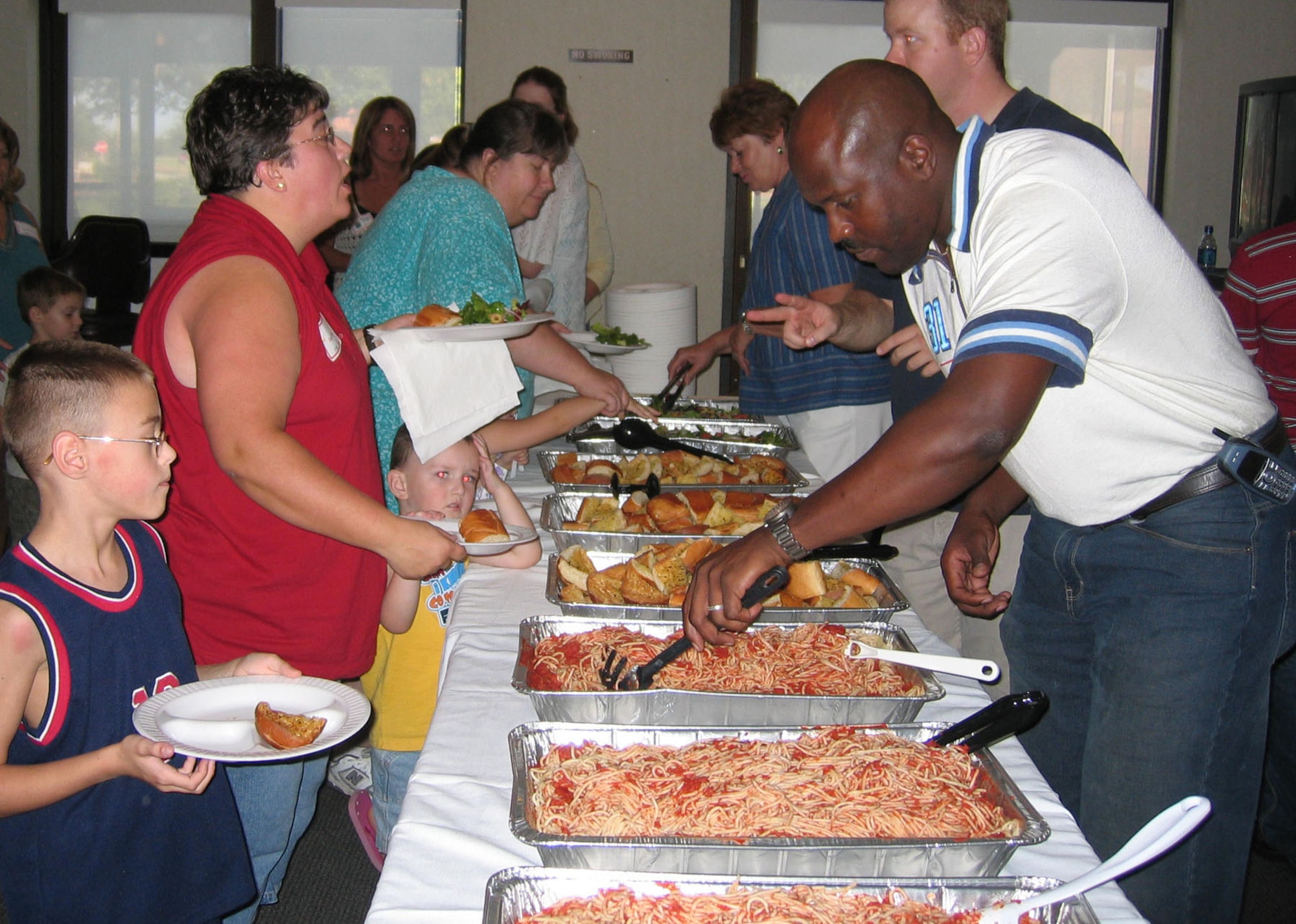DYESS AIR FORCE BASE, Texas -- Master Sgt. Brad Simpson, 7th Equipment Maintenance Squadron (right), serves a spaghetti dinner to families of deployed servicemembers at Dyess' inaugural Deployed Families Dinner Aug. 23 at the Hangar Center ballroom. Approximately 190 people attended the event. Food and door prizes were donated from members of the Abilene community, and the event was hosted by the spouses of the 7th EMS. (U.S. Air Force photo by Senior Airman Carolyn Viss)