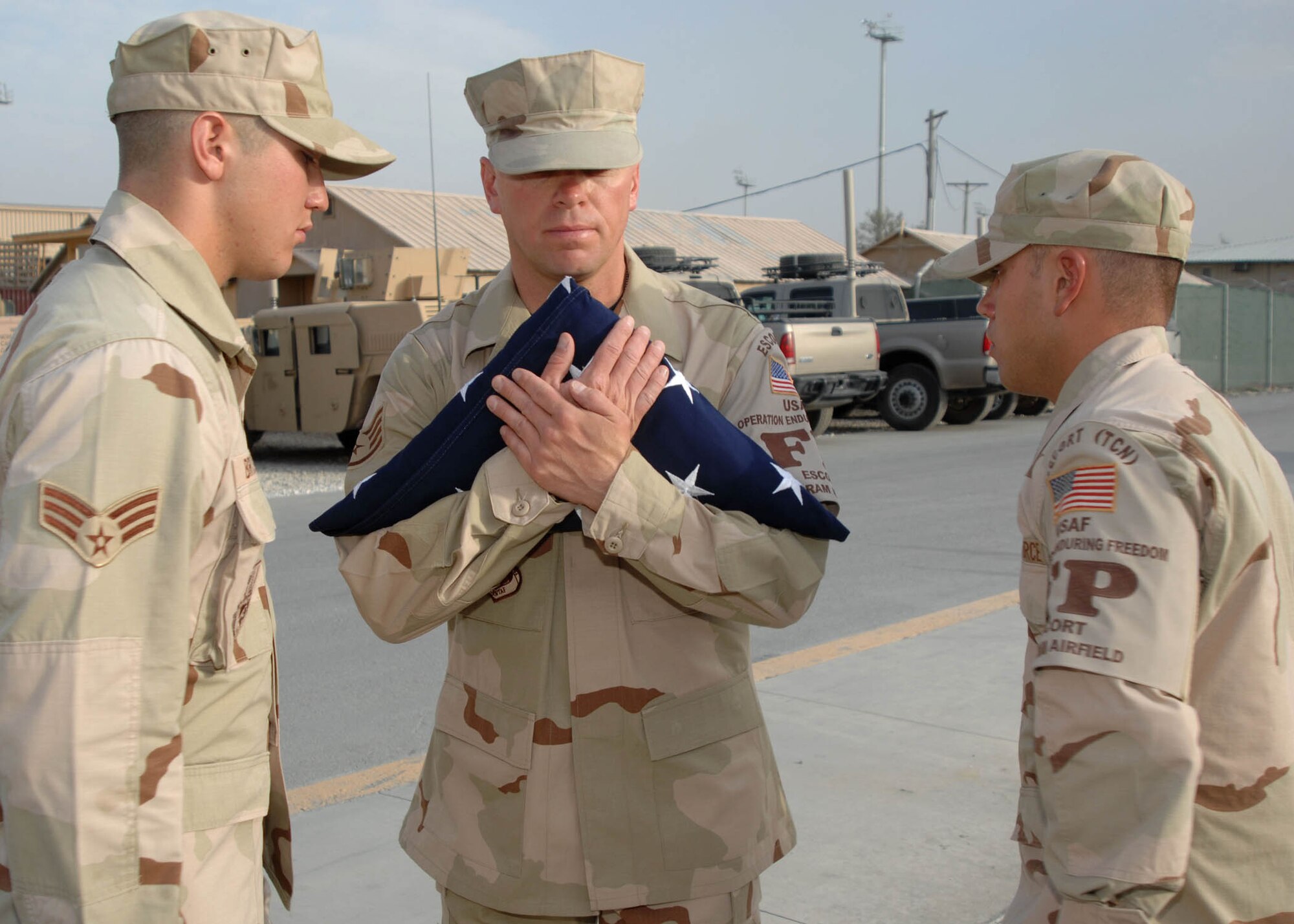 BAGRAM AIRFIELD, Afghanistan -- From left to right, Senior Airman Christopher Brooks, Staff Sergeant Lester Frye, and Senior Airman Peter Scalise, Force Protection members of the 455th Expeditionary Security Forces Squadron at Bagram Airfield, Afghanistan, prepare to retire the the American flag at the end of the retreat ceremony. (U.S. Air Force  photo by Senior Master Sgt. Kim Allain) 