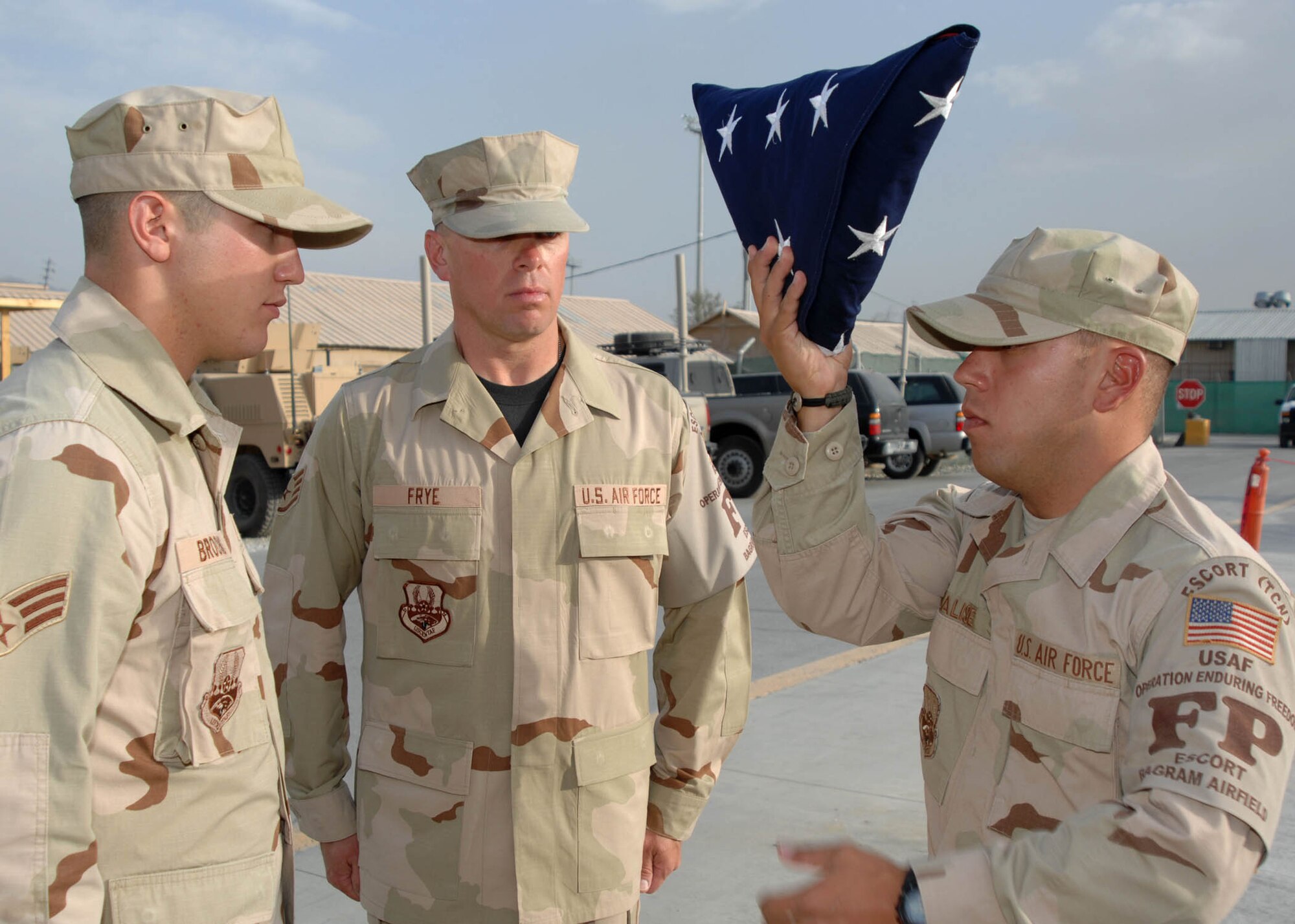 BAGRAM AIRFIELD, Afghanistan -- From left to right, Senior Airman Christopher Brooks, Staff Sergeant Lester Frye, and Senior Airman Peter Scalise, Force Protection members of the 455th Expeditionary Security Forces Squadron at Bagram Airfield, Afghanistan, raise the folded American flag during the retreat ceremony. (U.S. Air Force photo by Senior Master Sgt. Kim Allain) 