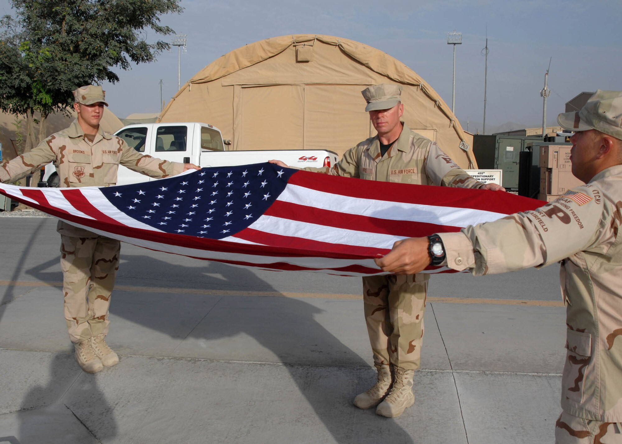 BAGRAM AIRFIELD, Afghanistan -- From left to right, Senior Airman Christopher Brooks, Staff Sergeant Lester Frye, and Senior Airman Peter Scalise, with the 455th Expeditionary Security Forces Squadron at Bagram Airfield, Afghanistan, perform flag security detail during the retreat ceremony. (U.S. Air Force photo by Senior Master Sgt. Kim Allain) 