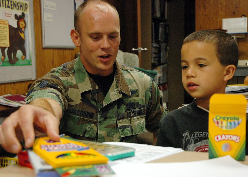 Staff Sgt. Brandon Jacobson, NCO in charge of network infrastructure for AFWA's 2nd Systems Operations Squadron, checks out some of the new school supplies with 8-year-old Lorenso Carey. An AFWA team collected some 200 pounds of assorted school supplies and delivered them Aug. 23 to Indian Hill Elementary School in Omaha. (Photo by G. A. Volb)