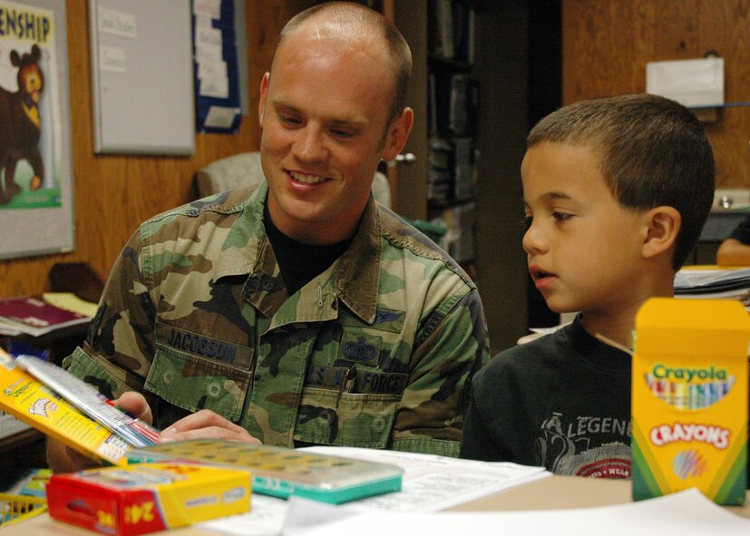 Staff Sgt. Brandon Jacobson, NCO in charge of network infrastructure for AFWA's 2nd Systems Operations Squadron, checks out some of the new school supplies with 8-year-old Lorenso Carey. An AFWA team collected some 200 pounds of assorted school supplies and delivered them Aug. 23 to Indian Hill Elementary School in Omaha. (Photo by G. A. Volb)