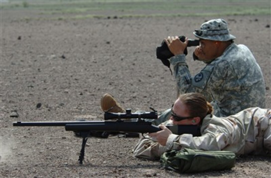 U.S. Navy Petty Officer 2nd Class Angela McLane fires an M-24 rifle while U.S. Army Sgt. 1st Class Ronald Brantley, from Guam National Guard's Delta Company, 1st Battalion, 294th Infantry, monitors her accuracy in Djibouti, Aug. 25, 2007.