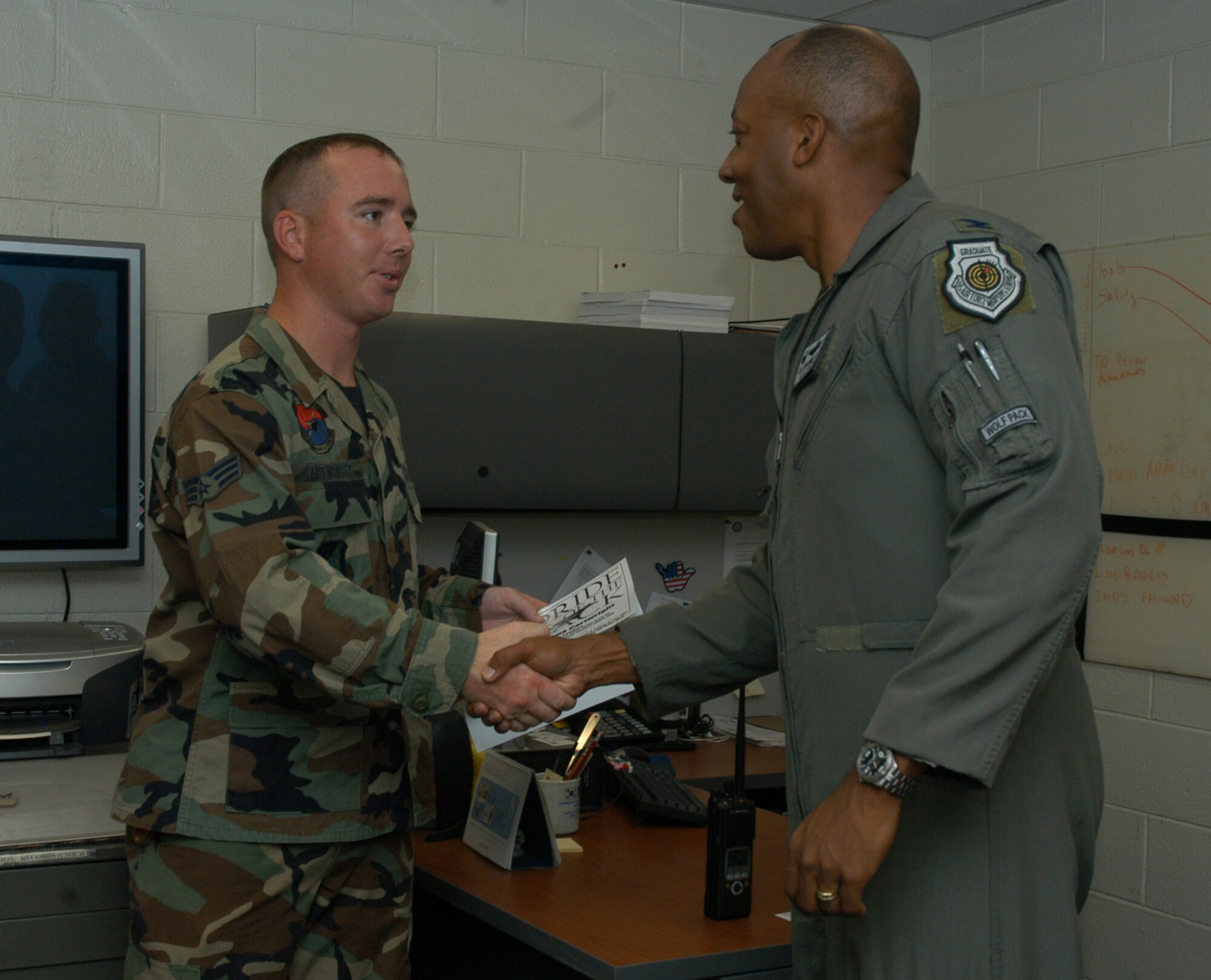 KUNSAN AIR BASE, South Korea -- Colonel CQ "Wolf" Brown, 8th Fighter Wing commander, congratulates Senior Airman Joshua Cartwright, 8th Communications Squadron cable maintenance technician here Aug. 21. Airman Cartwright was recognized as the 8th FW's Pride of the Pack for the week of Aug. 20. (U.S. Air Force photo/ Staff Sgt. Araceli Alarcon)                                                                                      