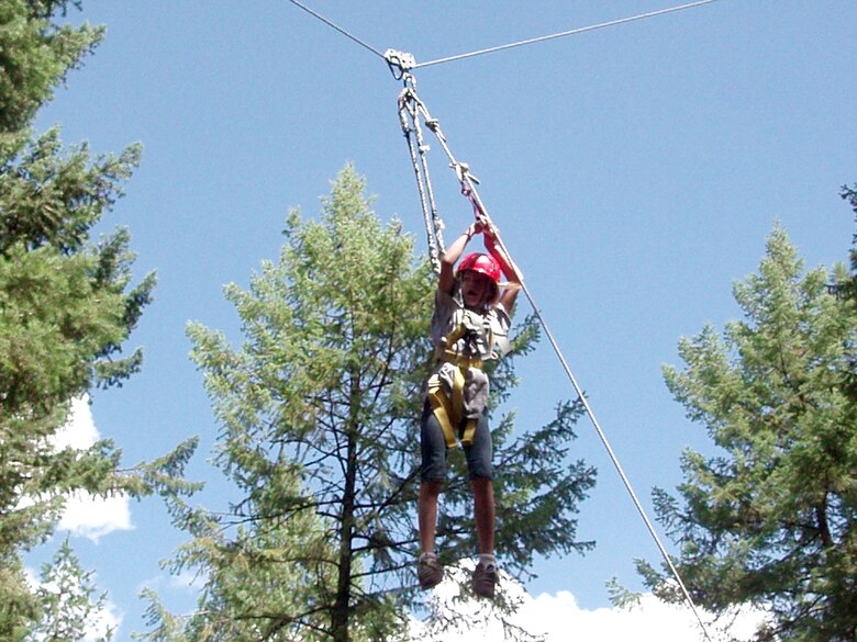 FAIRCHILD AIR FORCE BASE, Wash. – MaKenzie Oldenburg zips down the high-rope obstacle at the Adventure Dynamics ropes course near Spokane, Wash. MaKenzie, a student at Michael Anderson Elementary School here, attended the Drug Abuse Resistance Education program camp Aug. 20-24. The camp was open to students who finished a 10-week DARE classroom program, an international program that gives children skills to avoid drug, gang and violence involvement. (U.S. Air Force photo / Susan Conard)