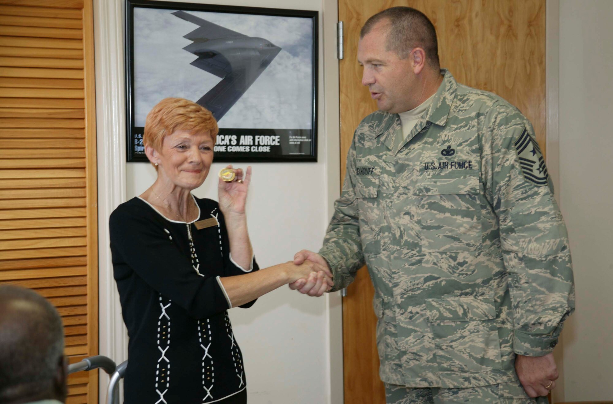 SUMTER, S.C. -- Chief Master Sgt. Scott Dearduff, 20th Fighter Wing command chief, presents a coin to Margaret Winston, Hopewell Healthcare activities director, after receiving a "care cushion" from the Hopewell residents Aug. 24. The residents wanted to present a special memento to the Shaw Air Force Base Airmen for their service to their country. (U.S. Air Force photo/Senior Airman Holly MacDonald)