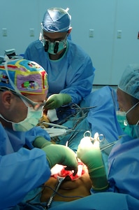 Surgical team members Maj. (Dr.) Christopher Dress, Maj. (Dr.) Dmitry Tuder and Airman 1st Class Angelia Sneed perform a free-flap operation on a 9-year-old girl suffering from a badly mangled leg. The procedure was the team's first free-flap operation at the Craig Joint Theater Hospital at Bagram Air Base, Afghanistan.  (U.S. Air Force photo)