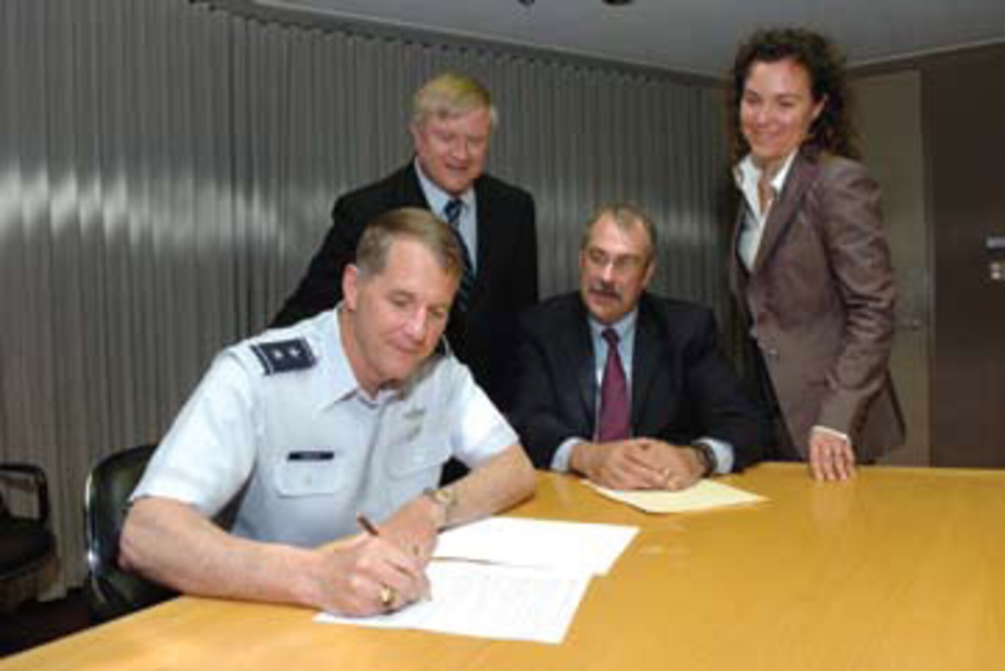 Major General Ted F. Bowlds, AFRL commander, signs an agreement between  AFRL and the Department of Energy’s Argonne National Laboratory as Mr. Jack Blackhurst, technical advisor, AFRL Plans and Programs Office; Dr. Al Sattelberger, Argonne’s interim associate laboratory director for applied science and technology; and Dr. Sandra Biedron, director of Argonne’s Department of Defense Project Office, look on (photo by George Joch).