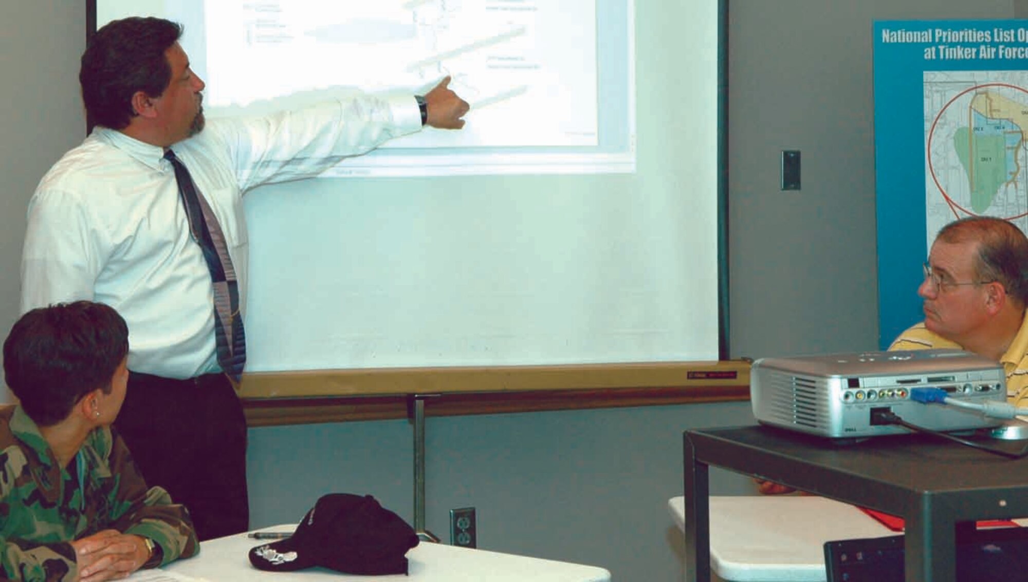 Albert Aguilar, Environmental Restoration chief shows a graph to help illustrate how the groundwater flow divide, which runs just north of the Tinker boundary to Interstate-40, keeps groundwater flow in a south westerly direction towards the base. (Air Force photo by Brion Ockenfels)