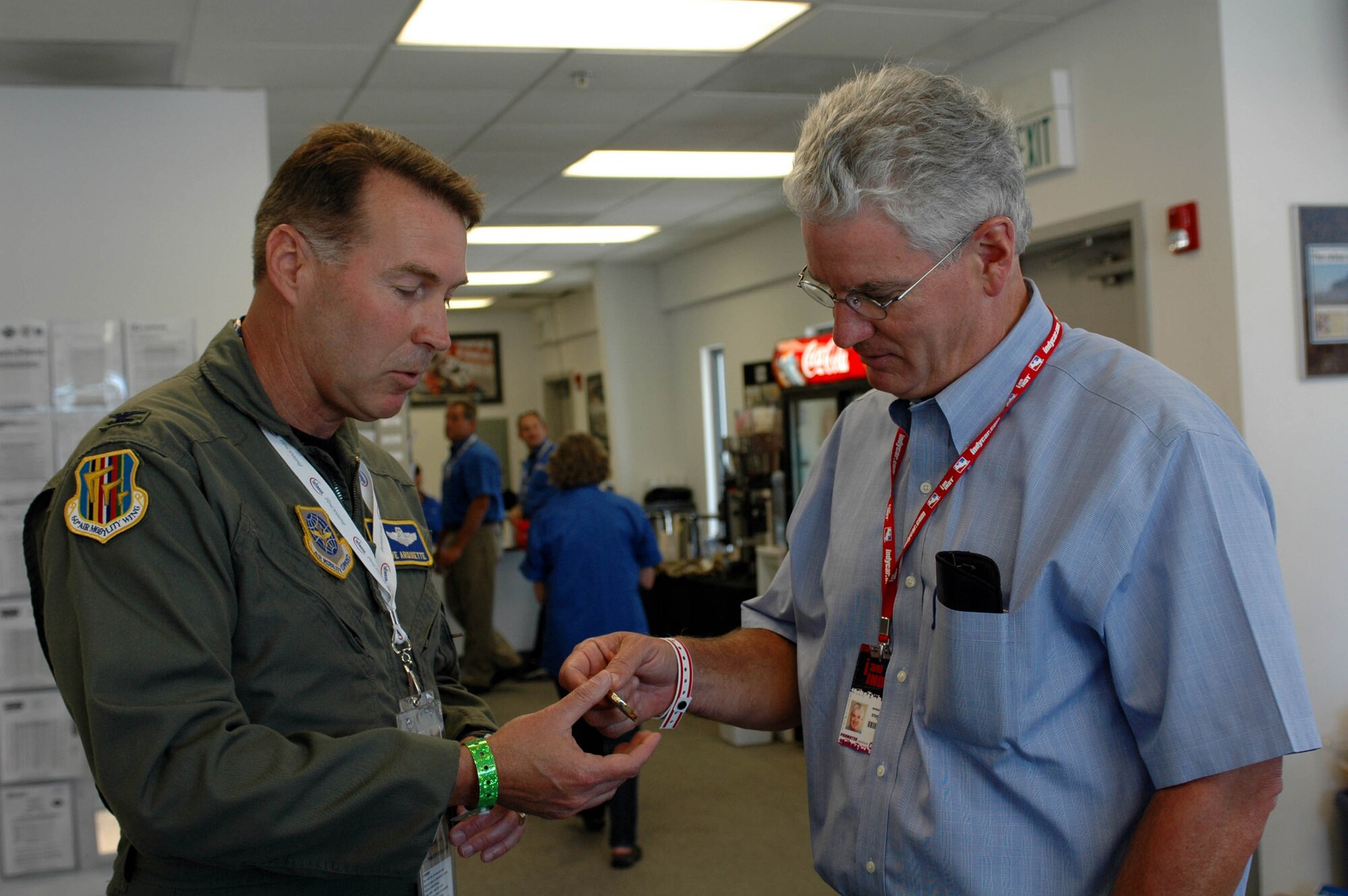 Col. Steve Arquiette, 60th Air Mobility Wing commander, presents a 60th AMW coin to Steve Page, president and general manager of Infineon Raceway before the Grand-Am Armed Forces 250 pre-race ceremonies Aug. 25 at Infineon Raceway, Sonoma, Calif. Colonel Arquiette was the event's grand marshal. (U.S. Air Force photo/Staff Sgt. Candy Knight)