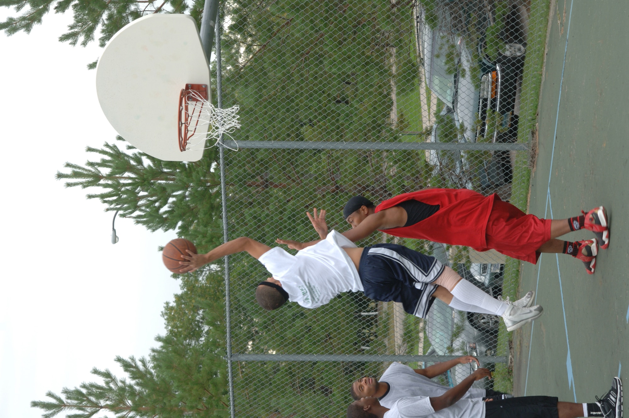 Senior Airman Daniel Oden, 319th Maintenance Squadron,  elevates over a defender to shoot the hook shot at the 3-on-3 basketball tournament during the Grand Forks Air Force Base Summer Bash Aug. 23. The base personnel and family members participated in several sports including basketball, bowling and horse shoes.  (U.S. Air Force photo/Airman 1st Class Chad M. Kellum)