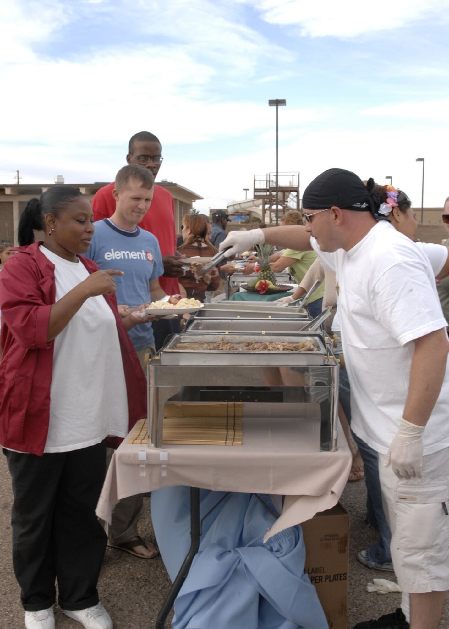 Holloman Airmen line up to eat at the end of summer luau held by the 49th Services Squadron Aug. 24. The luau had free food, swimming, movies and fun for everyone on base. (U.S. Air Force photo/Airman 1st Class Rachel Kocin)