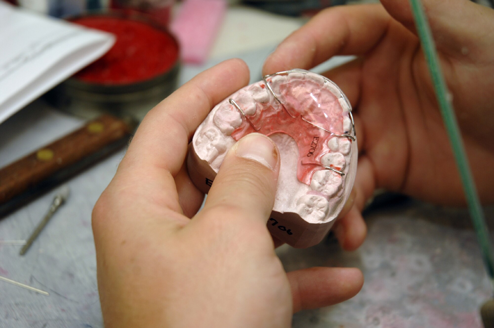 Senior Airman Charles Davis, a dental laboratory technician, repairs a retainer for a patient Aug. 24, at the RAF Lakenheath 48th Medical Group Dental Clinic. (U.S. Air Force photo by Airman 1st Class Erika Brooke)