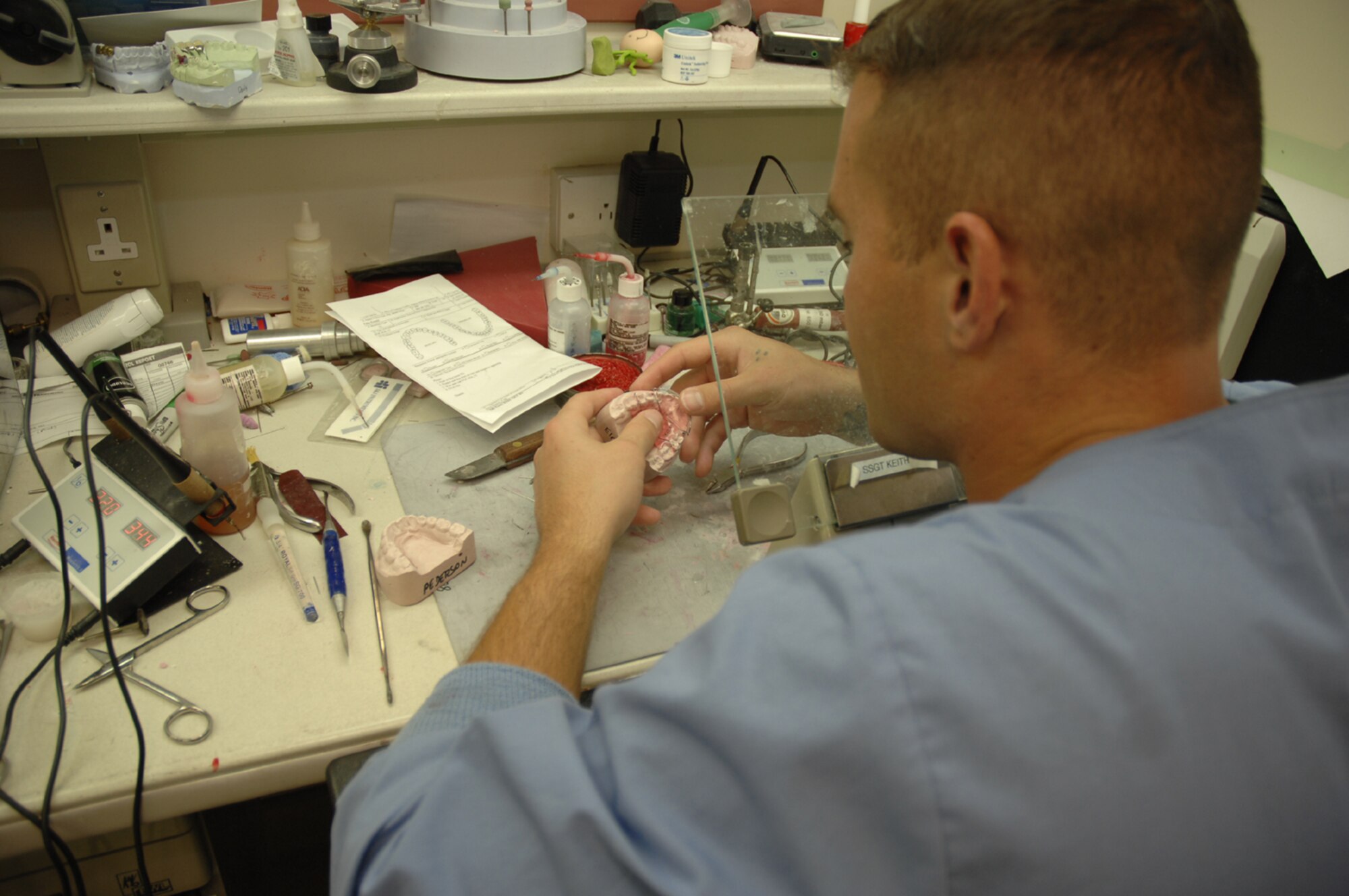 Senior Airman Charles Davis, a dental laboratory technician, repairs a retainer for a patient Aug. 24, at the RAF Lakenheath 48th Medical Group Dental Clinic. (U.S. Air Force photo by Airman 1st Class Erika Brooke)