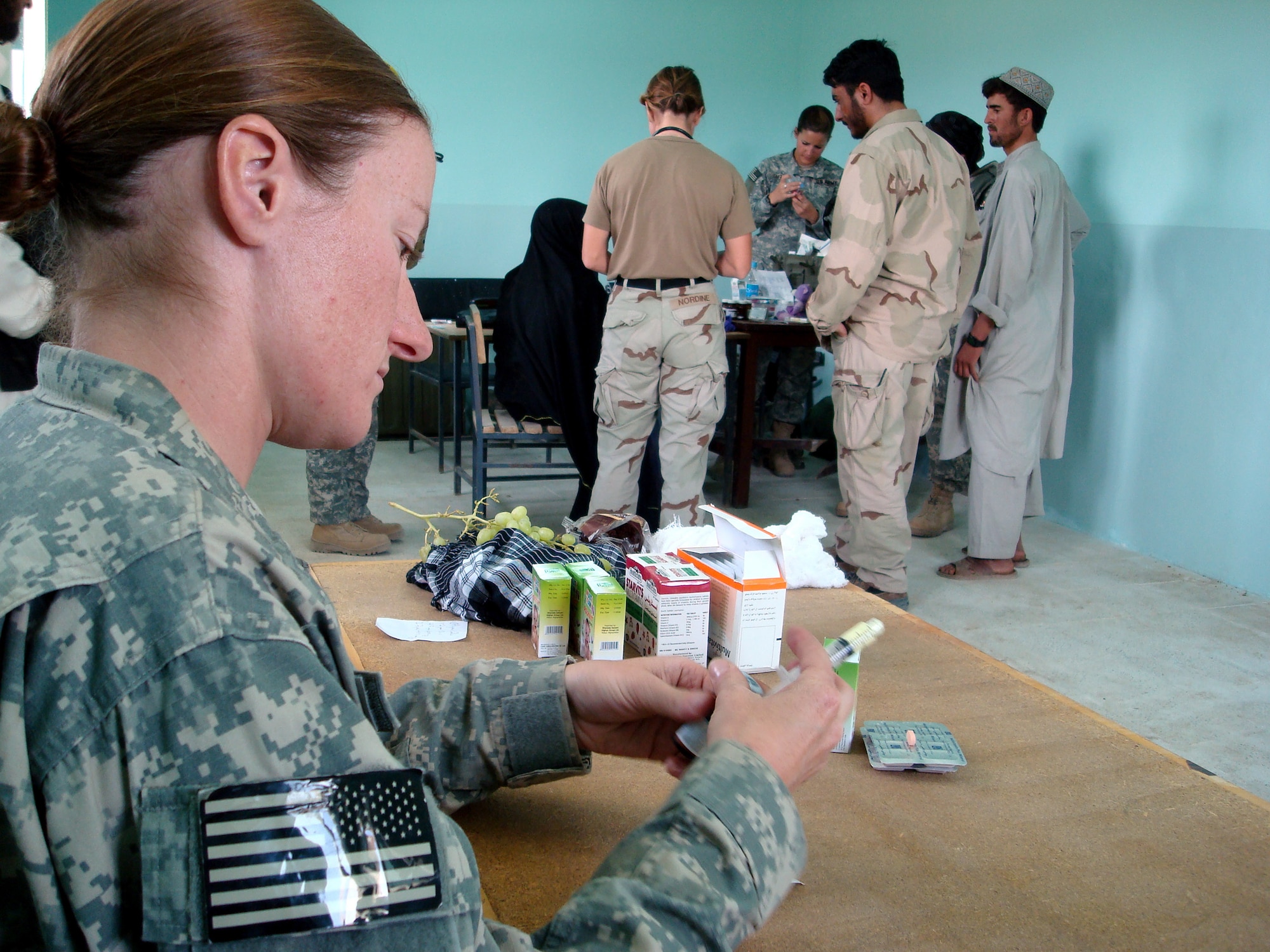 Staff Sgt. Jill Renshaw prepares de-worming medication for Afghan patients during a Village Medical Outreach Aug. 22 in the Shinkay District, Afghanistan. Nearly 200 people were seen by Provincial Reconstruction Team Qalat medics. (U.S. Air Force photo/Capt. Bob Everdeen) 
