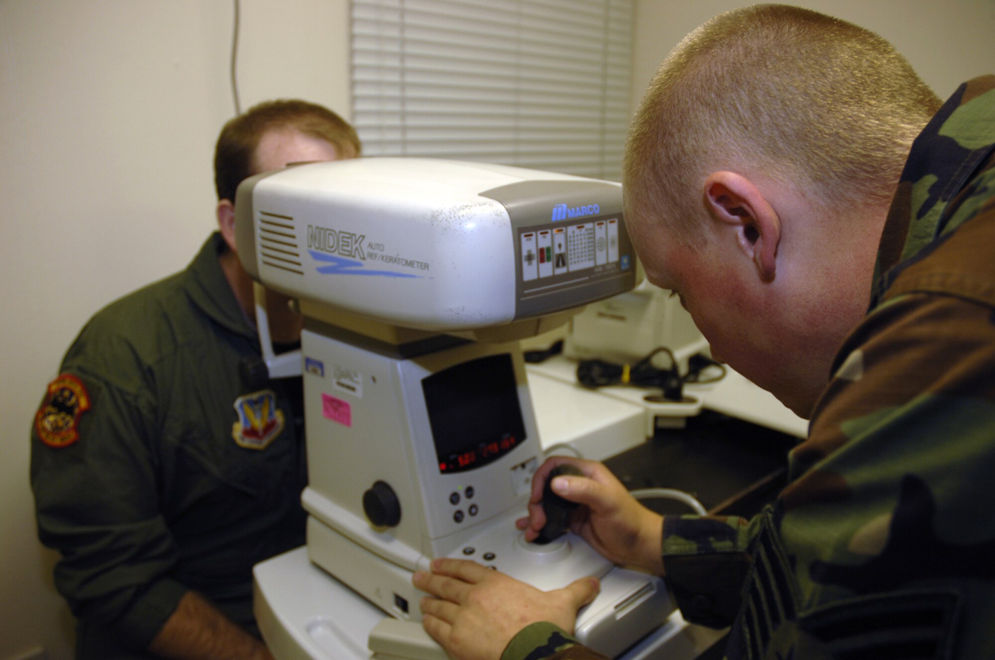 Staff Sgt. Greg O’Conner, optometry technician, 48th Aerospace Medical Squadron, tests a patients eyes Aug. 23. The Medical Group is currently studying different offices associated with the personal health assessment and individual mobility readiness medical programs as part of the Air Force Smart Operations of the 21st Century initiative. The initiative is helping them to determine whether they will be able to centralize all annual medical requirements, which should enable Airmen to complete their requirements in under a day. (U.S. Air Force photo by Airman 1st Class Jessica Snow)