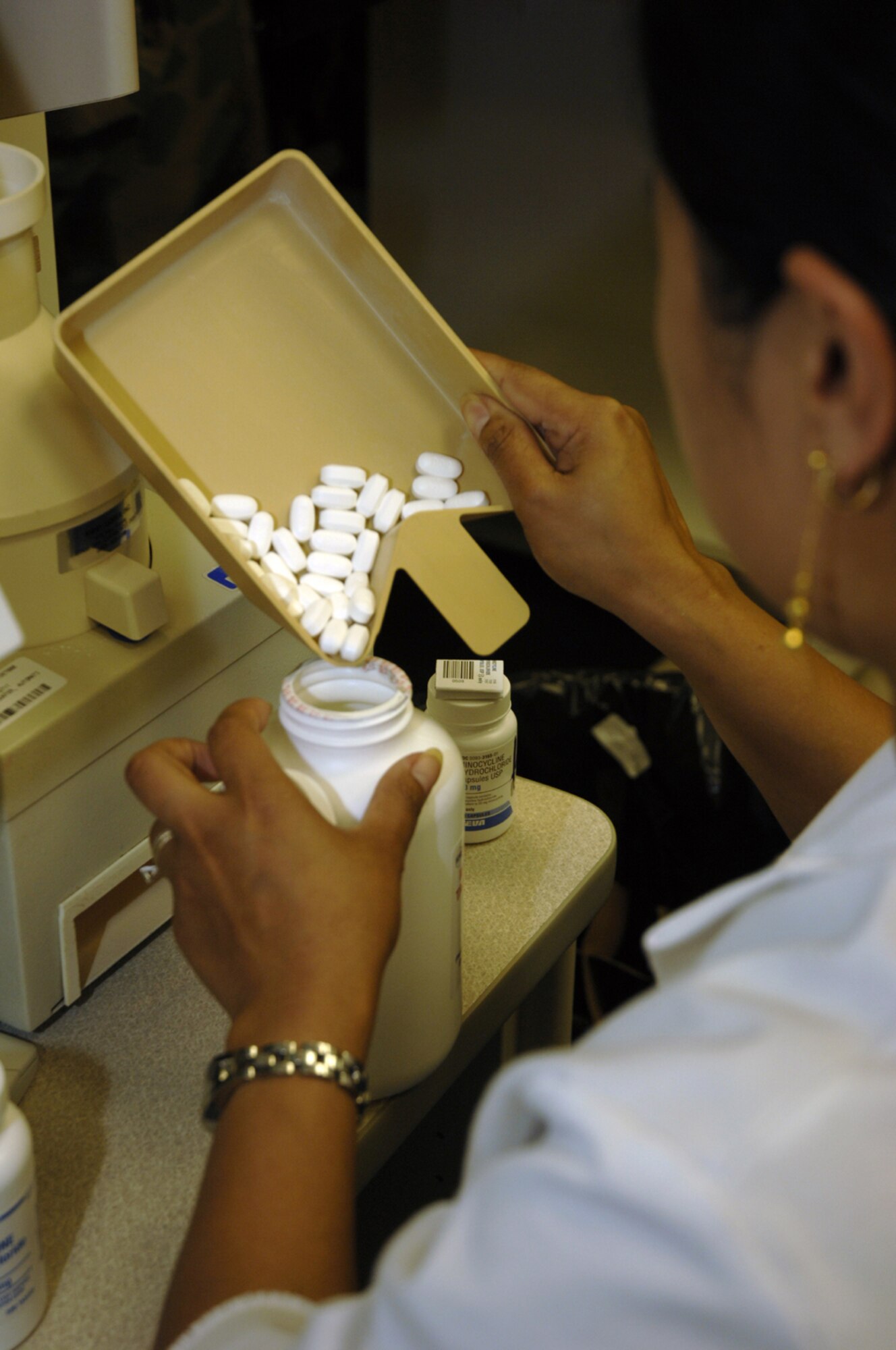 Rona Lawrence, pharmacy technician, 48th Medical Support Squadron, uses a pill counter while getting a prescription for a patient Aug. 23. The Medical Group is currently studying different offices associated with the personal health assessment and individual mobility readiness medical programs as part of the Air Force Smart Operations of the 21st Century initiative. The initiative is helping them to determine whether they will be able to centralize all annual medical requirements, which should enable Airmen to complete their requirements in under a day. (U.S. Air Force photo by Airman 1st Class Jessica Snow)