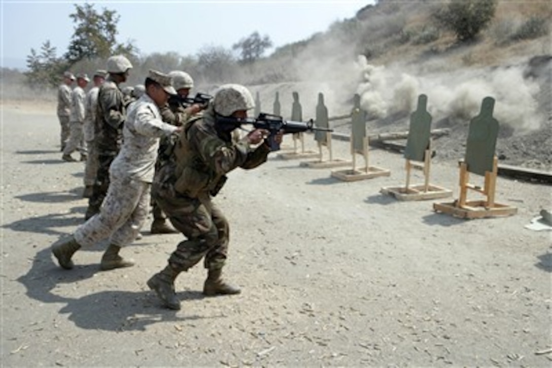 A U.S. Marine Corps instructor guides Tongan Marines as they fire their weapons during a target shooting exercise at Camp Pendleton, Calif., on Aug. 25, 2007. The Tongan Marines are participating in pre-deployment training with U.S. Marines at Camp Pendleton.  