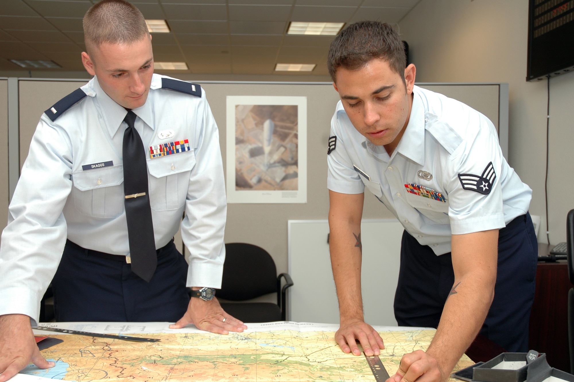 Senior Airman Chris Szopa, a 30th OSS Intelligence Flight intelligence analyst, shows his commander, 1st Lt. Ryan Skaggs, the location of a intelligence operation. Working with maps and the terrain of certain locations is a small portion of the intelligence gathering process.