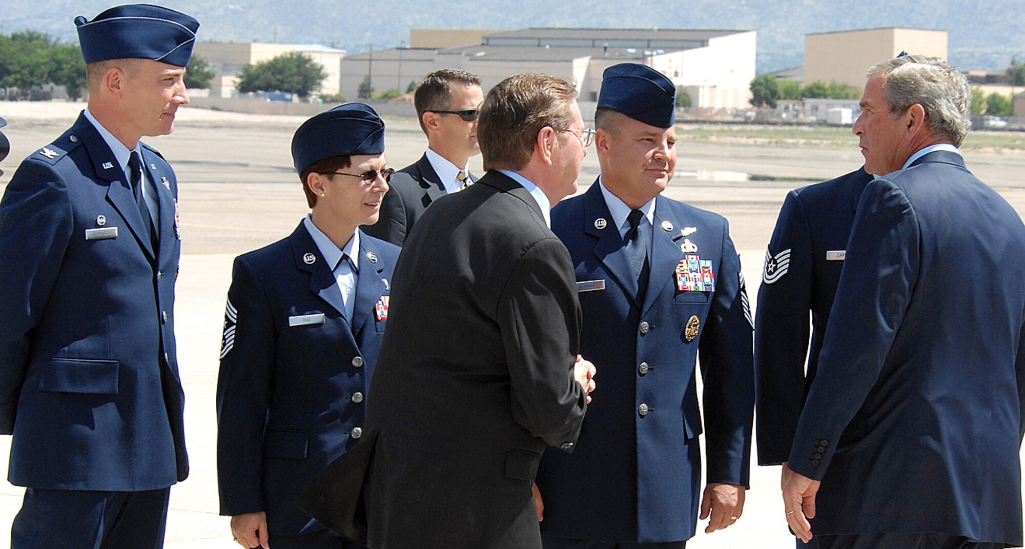 President George W. Bush greets members of Team Kirtland including from left, Col. Robert E. Suminsby Jr., 377th Air Base Wing commander, Chief Master Sgt. Judy Ruiz, 377th ABW command chief master sergeant, and Chief Master Sgt. Dennis Norman, 58th Special Operations Wing command chief master sergeant, as he arrives at Kirtland Air Force Base, New Mexico. He held a press conference at the flightline, Aug. 27, where he said progress is being made with Iraqi politicians. The president was in Albuquerque for a luncheon. U.S. Air Force photo by Todd Berenger