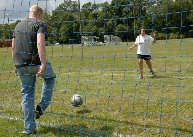Taylor Harrell, 437th Operations Group, helps and encourages Emily, a Dorchester Dragon Special Olympics soccer player, during the Special Olympics soccer kickoff event at the Summerfield Soccer Club Saturday. Harrell volunteers every Saturday as a coach for the team. (U.S. Air Force Photo/A1C Cynthia Spalding)