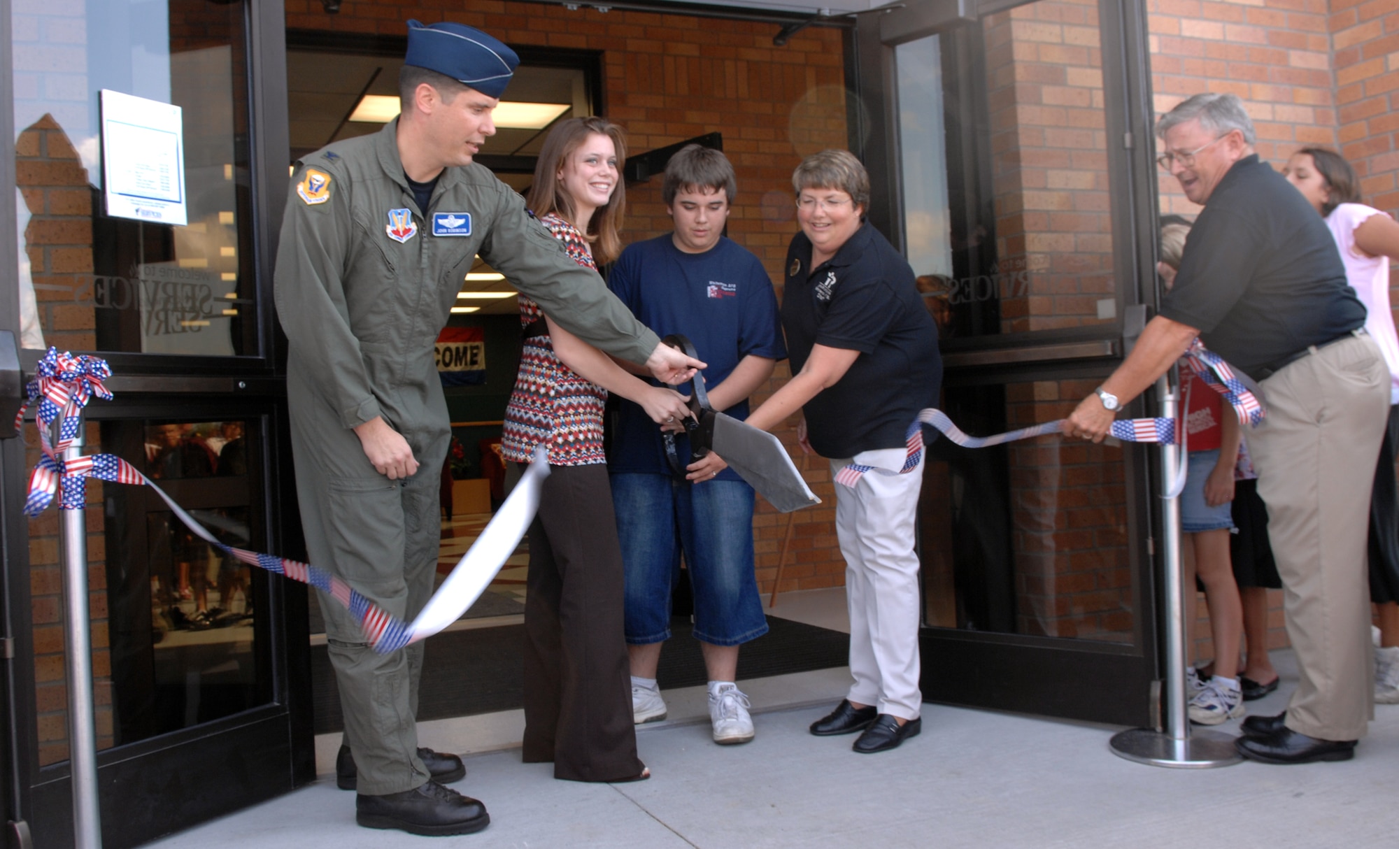 WHITEMAN AIR FORCE BASE, Mo. – Members of Team Whiteman cut the ribbon at the grand opening of the youth center Aug. 24. The $3.9 million youth center consists of a teen center for ages 13-18, three school-age classrooms for before and after school care, a gymnasium, a multi-purpose room, an art room, a music room, a computer room, a game room, a television lounge and instructional classroom. (U.S. Air Force photo/Airman 1st Class Stephen Linch)