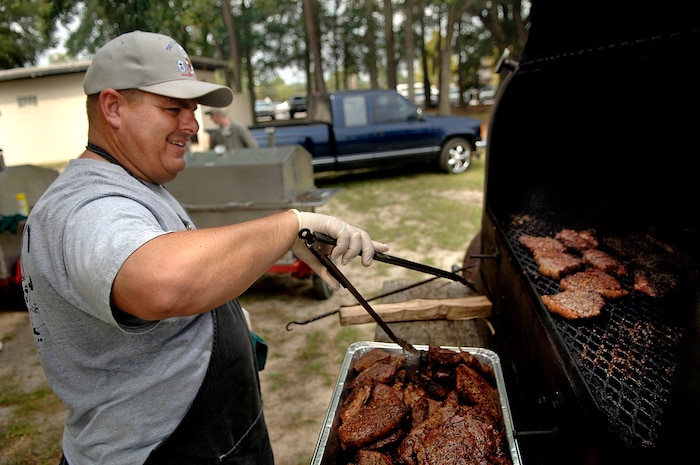 Senior Master Sgt. Bob Callahan, 15th Airlift Squadron superintendent, cooks steaks for the 437th Airlift Wing's Top Three annual steak-out Aug. 24 on the base picnic grounds. The menu included a steak, baked potato, corn on the cob and lemonade, ice tea or water. All the proceeds went to the E-1 to E-6 Oktoberfest for this year.   (U.S. Air Force photo/Airman 1st Class Nicholas Pilch) 