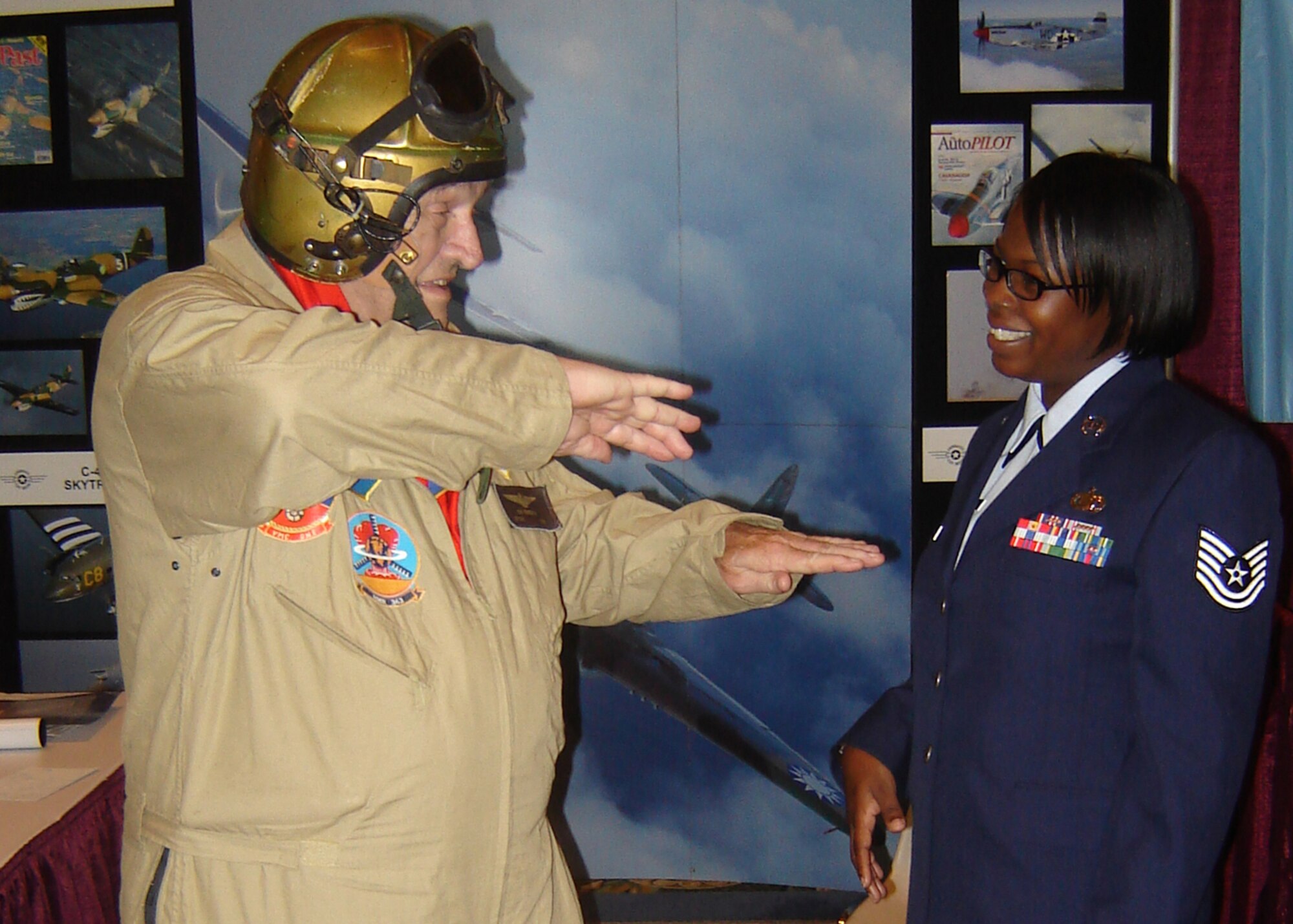 Former Marine Capt. Ken Branscome, who also is a volunteer at the Addison, Texas Cavanaugh Flight Museum, animatedly describes an AD Skyraider combat mission during the Korean War with Tech. Sgt. Torhonda Stults of the 22d Comptroller Squadron, McConnell Air Force Base, Kan.  Captain Branscome and Sergeant Stults were attending the 2007 Tuskegee Airmen, Inc. national convention in Grapevine, Texas. (U.S. Air Force photo by Mark Morgan)