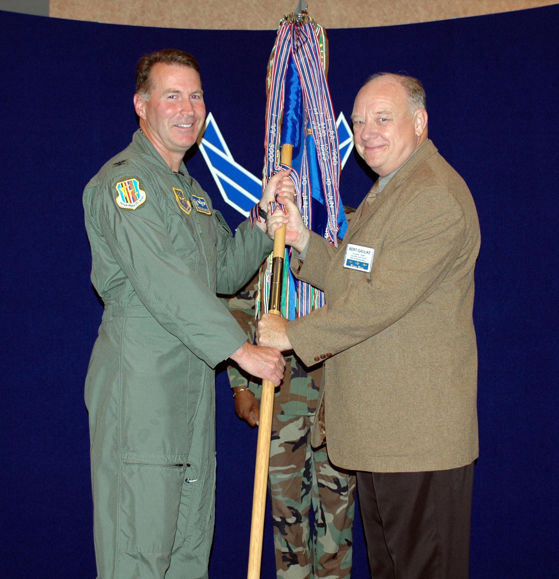 Bert Gaulke, Travis Regional Armed Forces Committee chairman, accepts honorary command of the 60th Air Mobility Wing from Col. Steve Arquiette, 60th AMW commander, during the honorary commanders’ assumption-of-command ceremony Aug. 24. The change-of-command ceremony is a military tradition dating back to Frederick the Great of Prussia. (U.S. Air Force photo/Staff Sgt. Candy Knight)