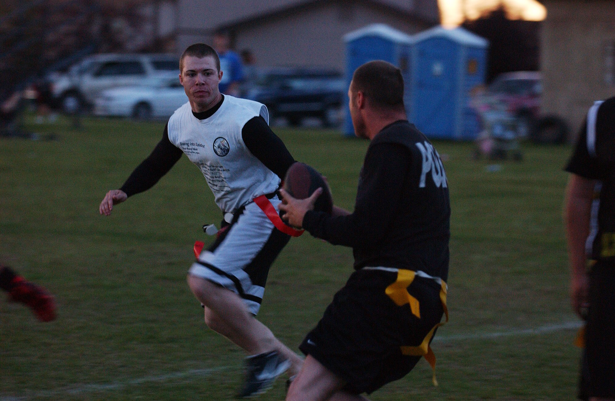 EIELSON AIR FORCE BASE, Alaska -- Airman 1st Class Christopher Griffin (back), 354th Fighter Wing Public Affairs, attempts to stop Staff Sgt. Jedadiah Schroeder (front), quarterback of the 354th Security Forces Squadron, Aug. 24. Security Forces went on to win the game 18-13. (U.S. Air Force Photo by Airman 1st Class Jonathan Snyder)
