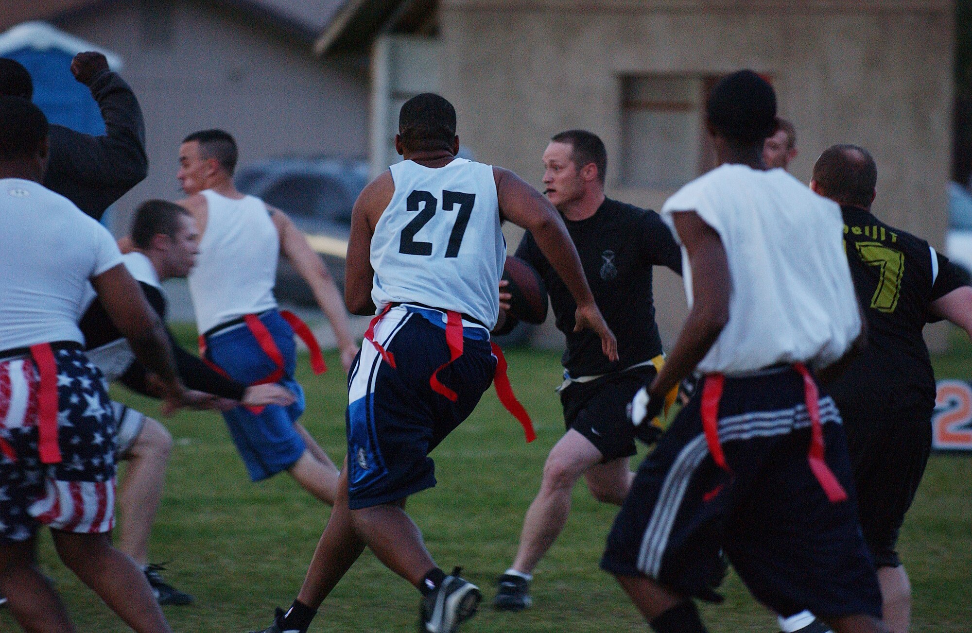 EIELSON AIR FORCE BASE, Alaska -- Staff Sgt. Jedadiah Schroeder (middle), 354th Security Forces Squadron, runs the ball down field while players of the 354th Communication Squadron close in Aug. 24. Security Forces went on to win the game 18-13. (U.S. Air Force Photo by Airman 1st Class Jonathan Snyder)