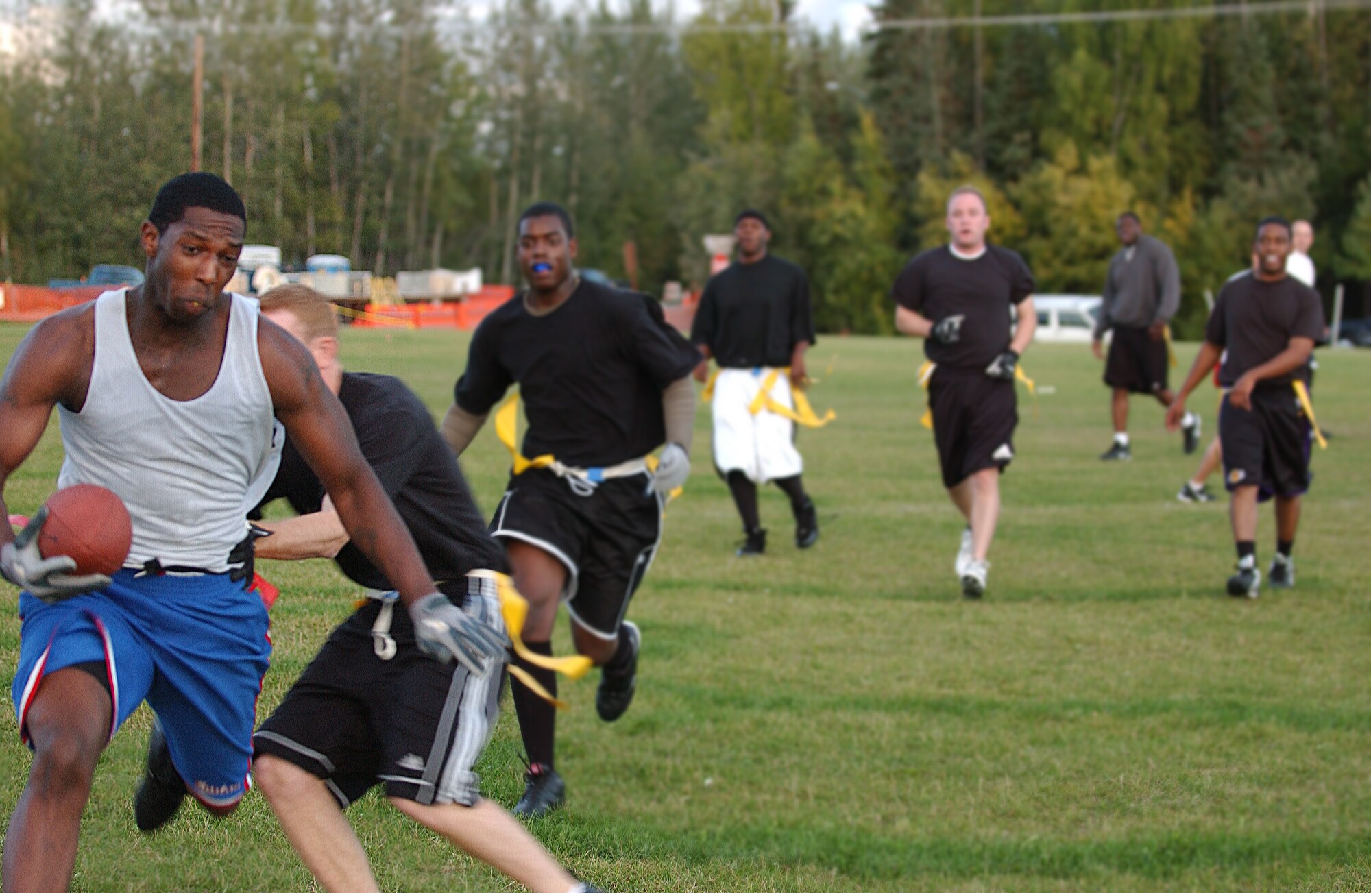 EIELSON AIR FORCE BASE, Alaska -- Airman 1st Class Lloyd Kelly, 354th Communication Squadron, runs down the field while players of the 354th Security Forces Squadron are closing in Aug. 24. Security Forces went on to win the game 18-13. (U.S. Air Force Photo by Airman 1st Class Jonathan Snyder)