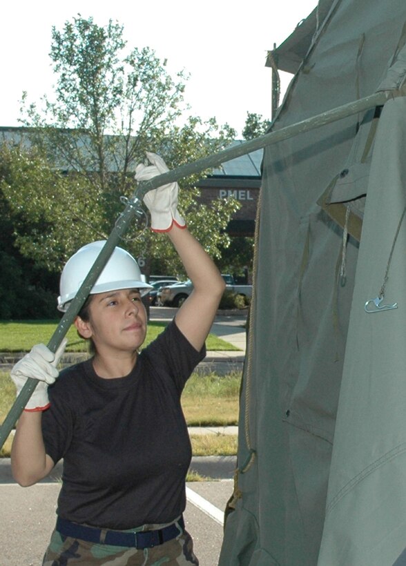 PETERSON AIR FORCE BASE, Colo. -- Senior Airman Cindy Rojas, 302nd Services Flight services apprentice, disassembles a tent during recent mobility training in preparation for the December Operational Readiness Inspection. For more, see page 3. (U.S. Air Force photo/Tech. Sgt. Tim Taylor)