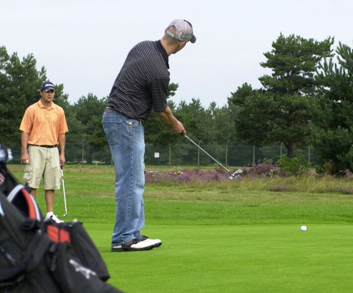 Daniel Montgomery, 100th Aircraft Maintenance Squadron sinks a 30-foot putt on the eighth green in the semi-finals of intramural golf at Breckland Pines Golf Club, Aug 28, while playing partner John Donahue looks on. (Air Force photo by Gary Rogers)