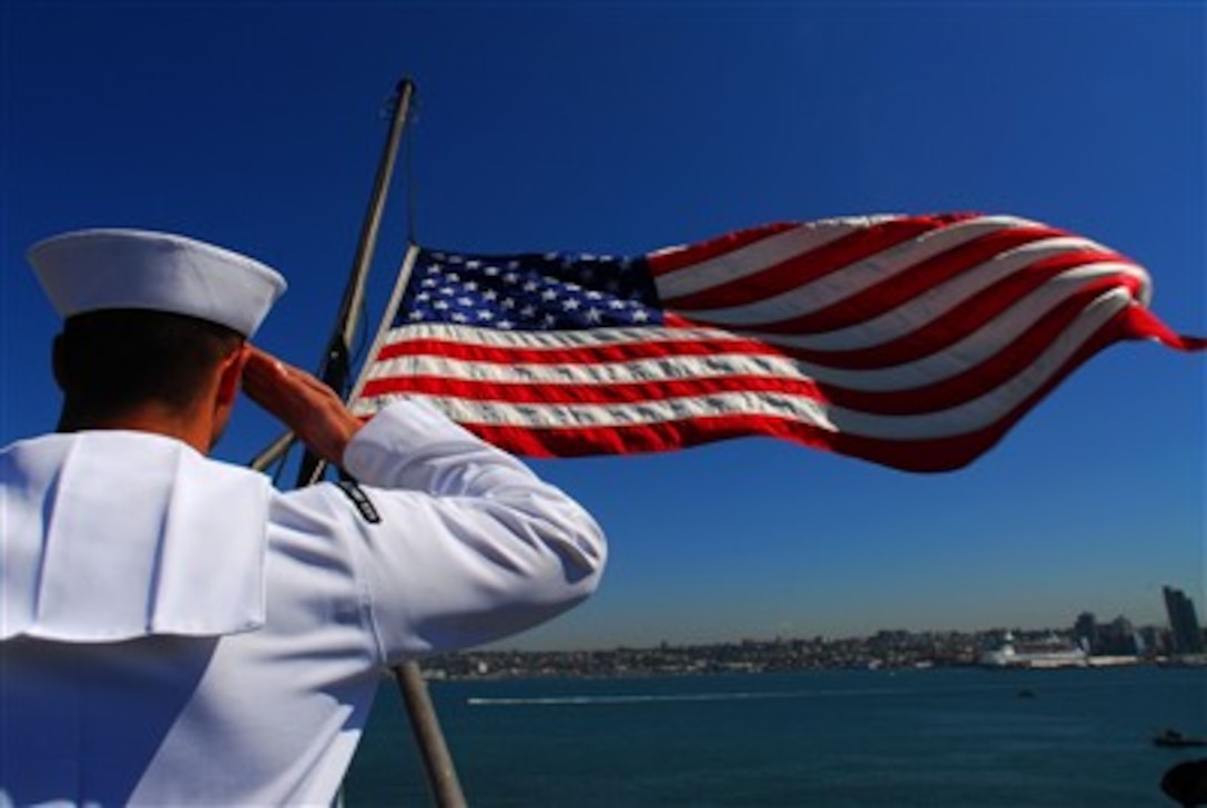 A sailor salutes the American flag on the flight deck of the Nimitz-class aircraft carrier USS John C. Stennis as the ship departs San Diego, Calif., Aug. 28, 2007, to return to its homeport of Bremerton, Wash. 