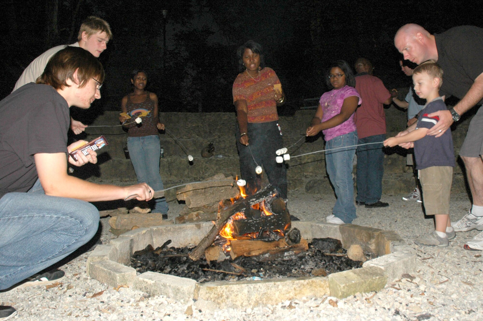 MCCONNELL AIR FORCE BASE, Kan. – Team McConnell members roast marshmallows in a fire camp during the 22nd Maintenance Group Reunion and Reintegration Aug. 25 at the Rock Springs 4-H Center, near Junction City, Kan. Archery, horseback riding, trap and rifle shooting were among some of the activities retreat members could participate in. The day’s activities ended with a camp fire. More than 70 military members, some recently returned from deployment, and their families participated in the event. (U.S. Air Force photo by Tech. Sgt. Chyrece Campbell)