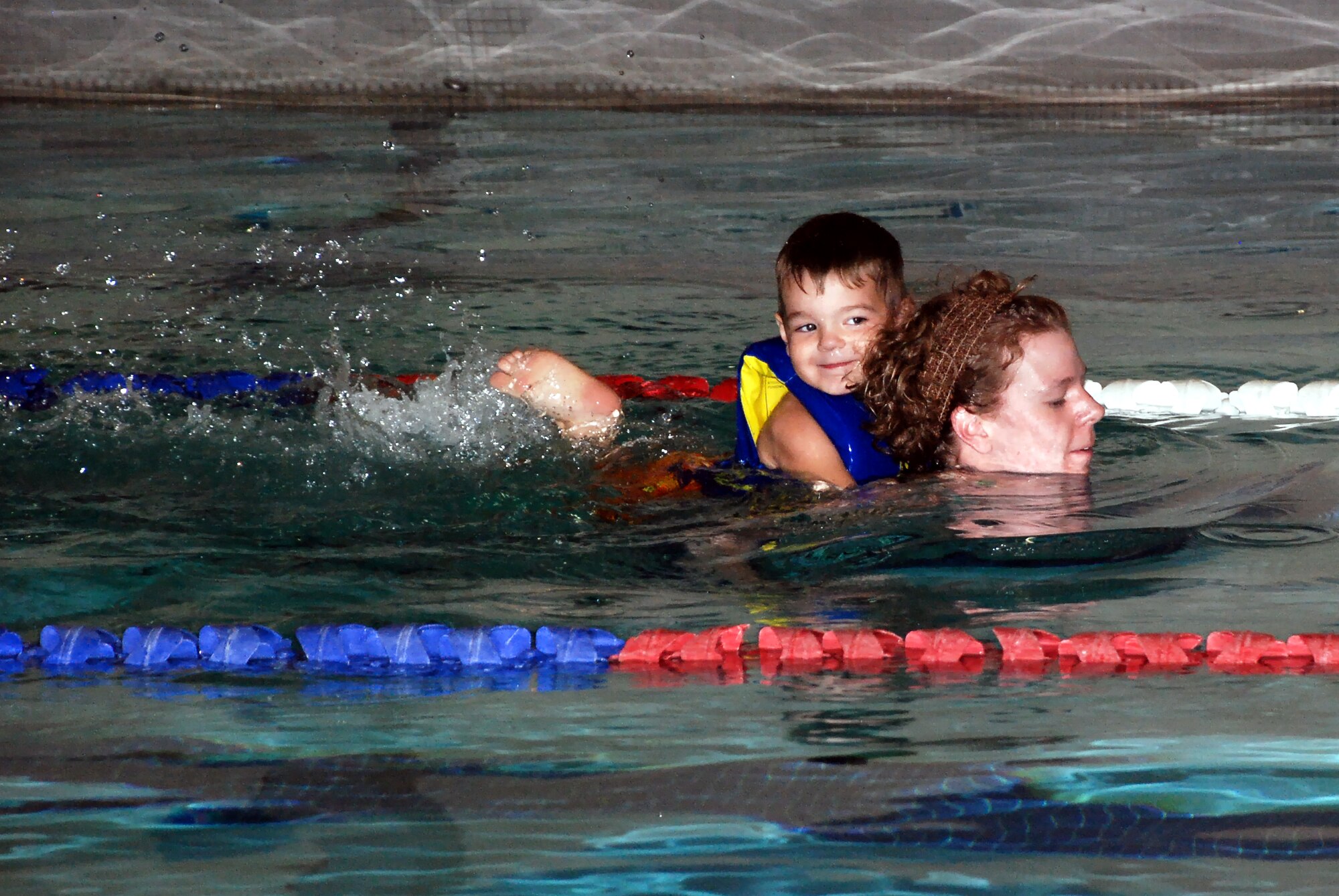 FAIRCHILD AIR FORCE BASE, Wash. – Alex Caldwell, 3, floats a ride on Mom’s back, Tech. Sgt. Rebecca Caldwell of the Health and Wellness Center. Alex participated in the Kids Wellness Triathlon here Aug. 25, a swim-bike-run event that was open to children through age 15. Triathlon distances varied based on age; Alex’s age group swam 25 yards at the indoor pool, biked one mile on a closed-road course and swam one fourth of a mile on a paved track. (U.S. Air Force photo / Staff Sgt. Mikel Daniel)