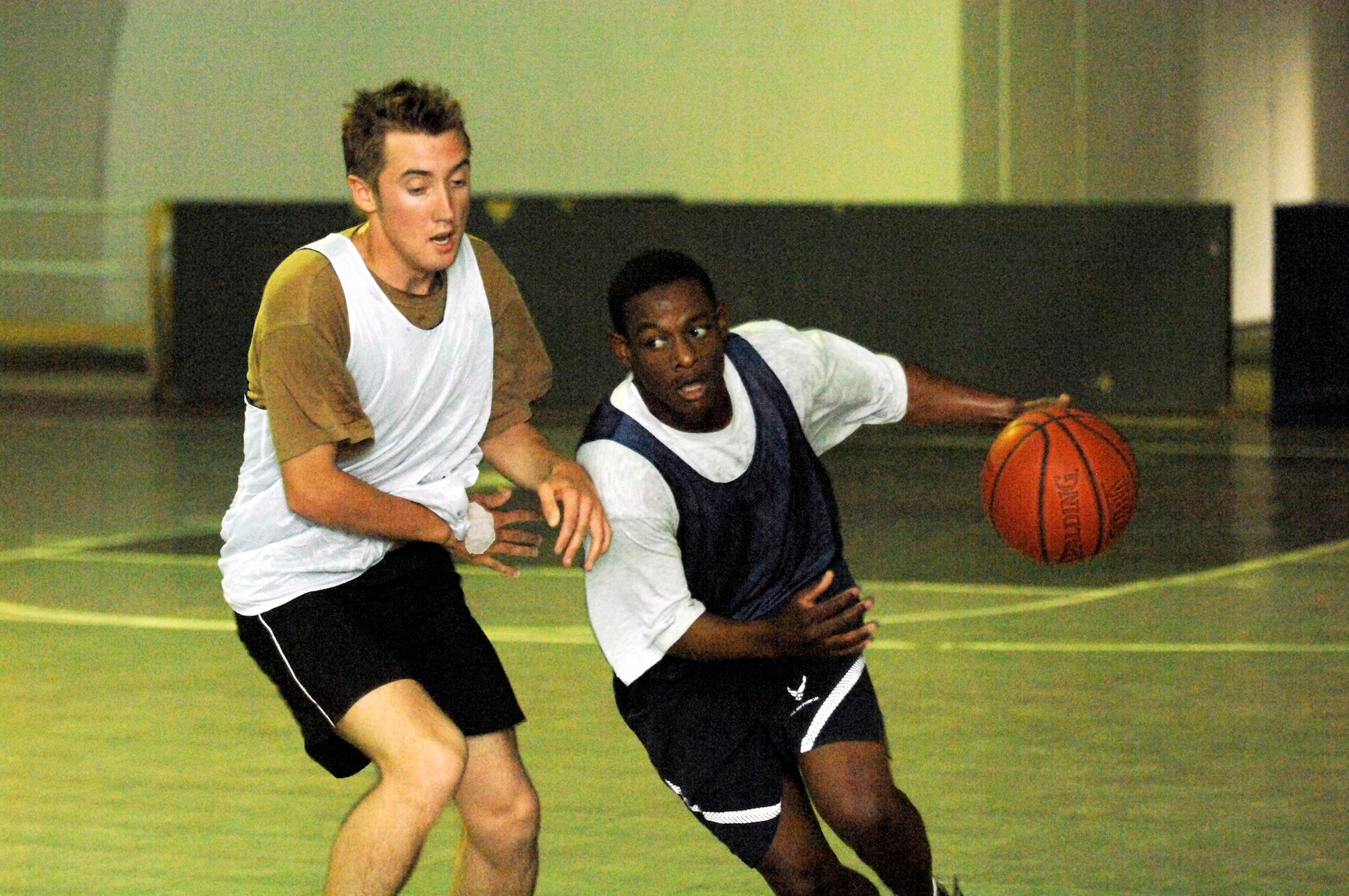 Senior Airman Michael Gray drives past an Australian team defender during the first-ever coalition games Aug. 20 at Camp Adder, Iraq. The Air Force team took third place in the event. The coalition games brought together different sport teams from the Air Force, Army, Navy, Australians and the Romanians to compete for the bragging rights as the best on base. The Air Force came out on top taking first place in five events. Airman Gray is a member of the 407th Security Forces Squadron at Ali Base, Iraq. (U.S. Air Force photo/Master Sgt. Robert W. Valenca)
