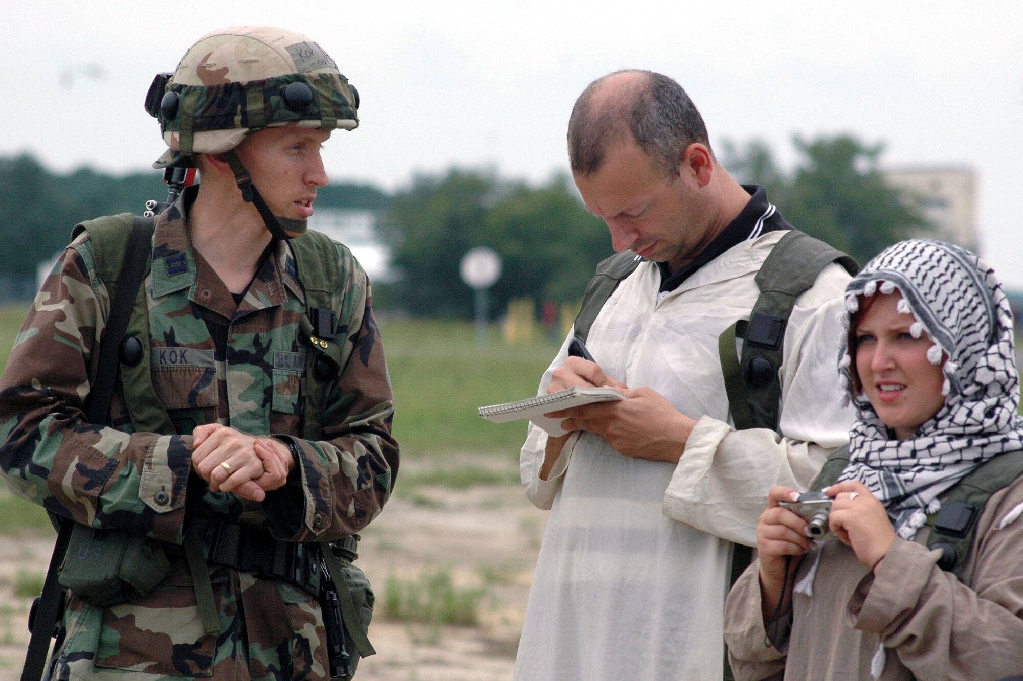 Capt. Andre Kok, deployed with the fictional 421st Air Expeditionary Group from Air Education and Training Command Public Affairs from Randolph Air Force Base, Texas, talks with the local media during operations for Air Force Exercise Eagle Flag 07-6 Aug. 26 at Naval Air Engineering Station Lakehurst, N.J.  The local media are played by Tech. Sgt. Ryan Mattox, Air Force News, San Antonio, Texas, and Airman 1st Class Emerald Ralston, Malmstrom AFB, Mont.  The exercise is coordinated by the U.S. Air Force Expeditionary Center's 421st Combat Training Squadron at Fort Dix, N.J.  (U.S. Air Force Photo/Tech. Sgt. Scott T. Sturkol)