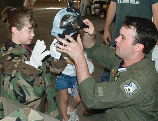 Staff Sgt. Daric Franco, 965th Airborne Air Control Squadron, fits 9-year-old Kylee Johnson with protective gear at last year’s Kids Understanding Deployment Operations. (Air Force photo by Ralph Monson)