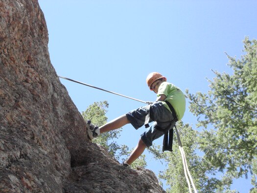 Ryan Gonzalez rappels down a cliff face at Big Rock Creek Adventure Camp in Valyermo, Calif. Youth Center children visited Big Rock Creek as part of an Edwards Youth Center summer camp. The center’s before and after program provides activities during the summer such as bowling, swimming, summer camp and amusement park trips.  (Photo by Sharon Harmon)