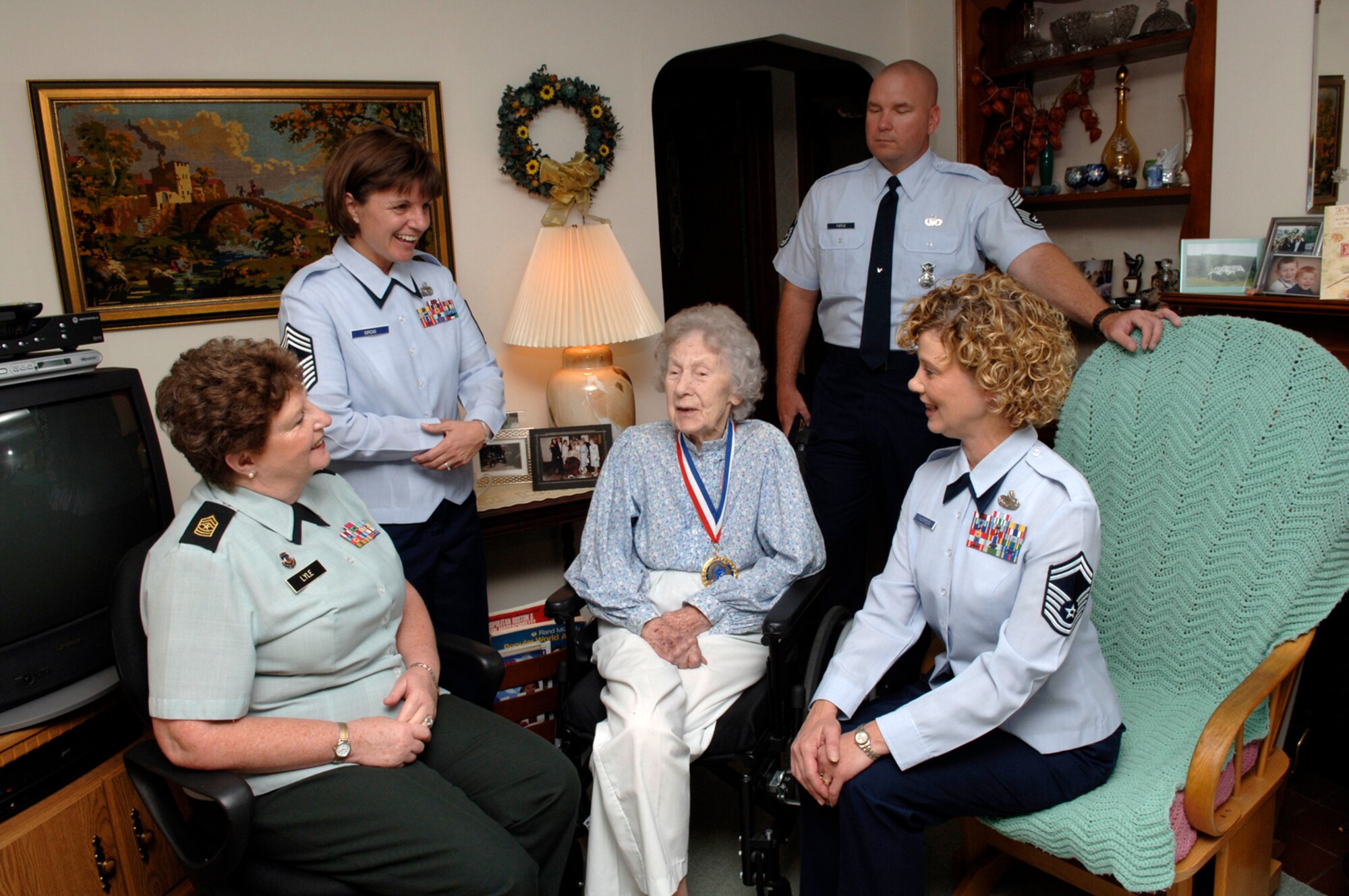 HANSCOM AFB, Mass. -- Retired Chief Master Sgt. Esther MacKay, center, is visited by retired Army Sgt. Maj. Beth Lyle, seated left, Senior Master Sgt. Ginger Thompson, seated right, Command Chief Master Sgt. Lisa Sirois, standing left, and Chief Master Sgt. Tom Purtle, standing right, at her home Aug. 29. 

The group of E-9s from Hanscom (Sergeant Thompson will be promoted to chief master sergeant later this year) came to Chief MacKay’s home in Needham to personally present her with a plaque and medallion on behalf of the Charter Chief’s Group, which appointed her an Honorary Charter Chief. The Charter Chief’s Group was formed by the first group of men who were promoted to chief master sergeant in 1959. Chief MacKay is the third woman to be appointed an Honorary Charter Chief. The visit was also attended by Needham Selectman James Healey, as well as representatives from Congressman Stephen Lynch’s office, and State Representative Lida Harkins’ office.

Chief MacKay, who served from 1943 to 1965, shared some of her service memories with the group and described what being a woman in the service was like at a time when men dominated the Armed Forces. “Every minute was a challenge; I loved every minute of it,” she said. 

At 102 years old, Chief MacKay is the Air Force’s oldest chief master sergeant. (U.S. Air Force photo by Walter Santos)