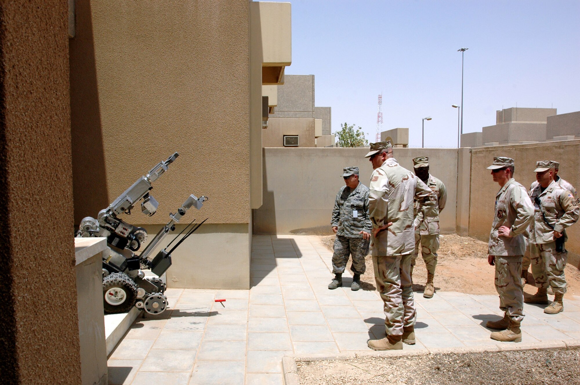 Brig. Gen. Charlie Lyon (left) watches as a 64th Air Expeditionary Group explosive ordnance disposal robot prepares to enter a building to defuse a simulted improvised explosive device during a base exercise Aug. 20 at a foward deployed location in Southwest Asia. General Lyon is the 379th Air Expeditionary Wing commander. (U.S. Air Force photo/Capt. Teresa Sullivan) 
