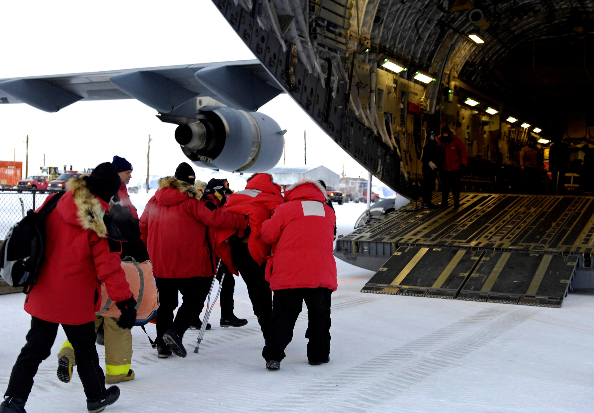 A patient is helped onto a C-17 Globemaster III Aug. 28 at Pegasus White Ice Runway, Antarctica. After completing the Operation Deep Freeze winter fly-in, a C-17 crew turned around 24 hours later and flew a medical evacuation for a patient who required more definitive medical treatment than Antarctica could handle. Also on board was a medical team from the 446th Aeromedical Evacuation Squadron from McChord Air Force Base, Wash. (U.S. Air Force photo/Tech. Sgt. Shane A. Cuomo)