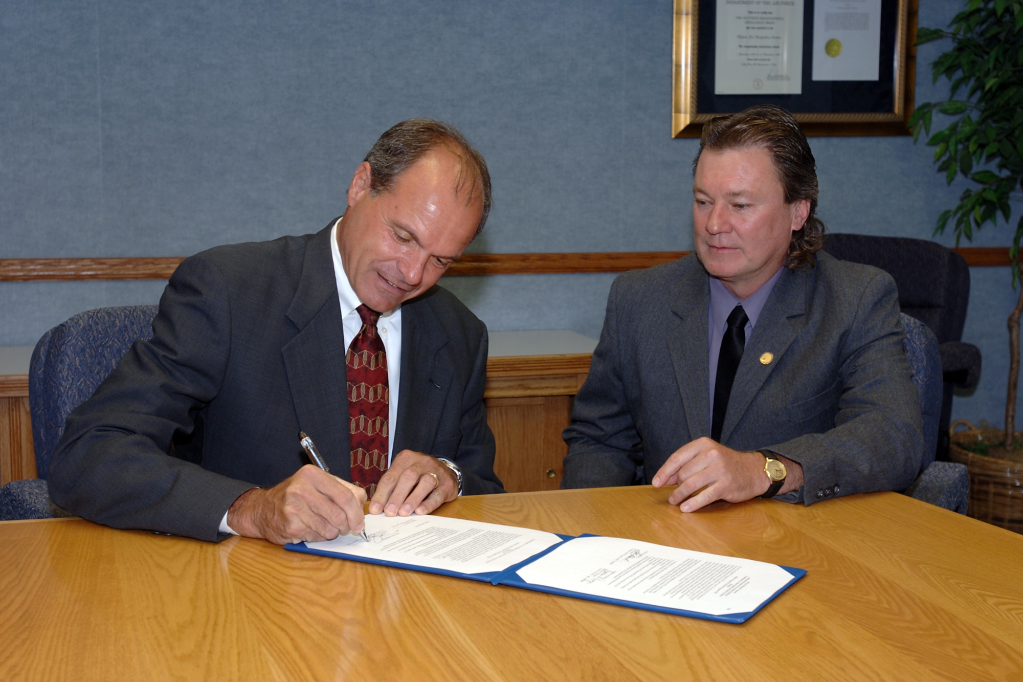 Don Cazel (left), Ogden Air Logistics Center deputy director, and Troy Tingey, local union president, sign a Voluntary Protection Program agreement Aug. 15. The agreement shows both Team Hill's and the union's commitment to safety. (U.S. Air Force Photo by Alex R. Lloyd)